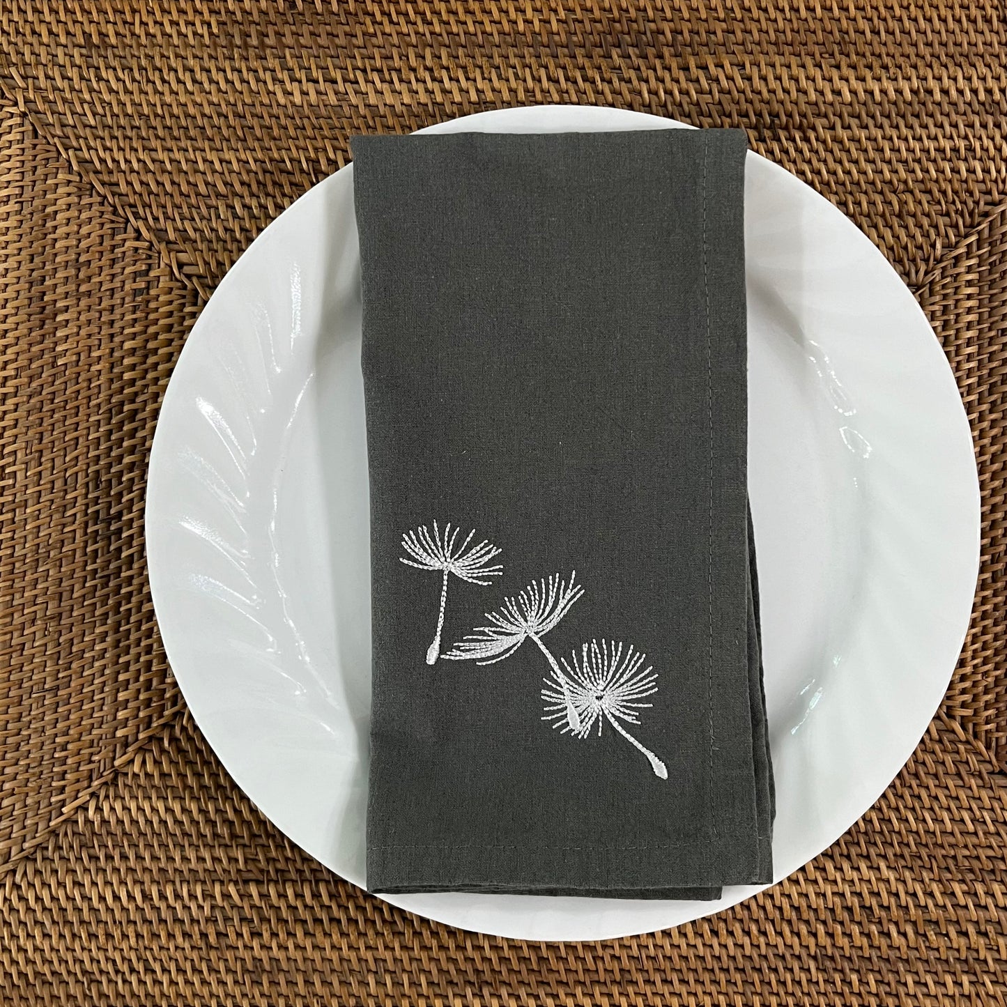 Blowing dandelion embroidered on grey napkin