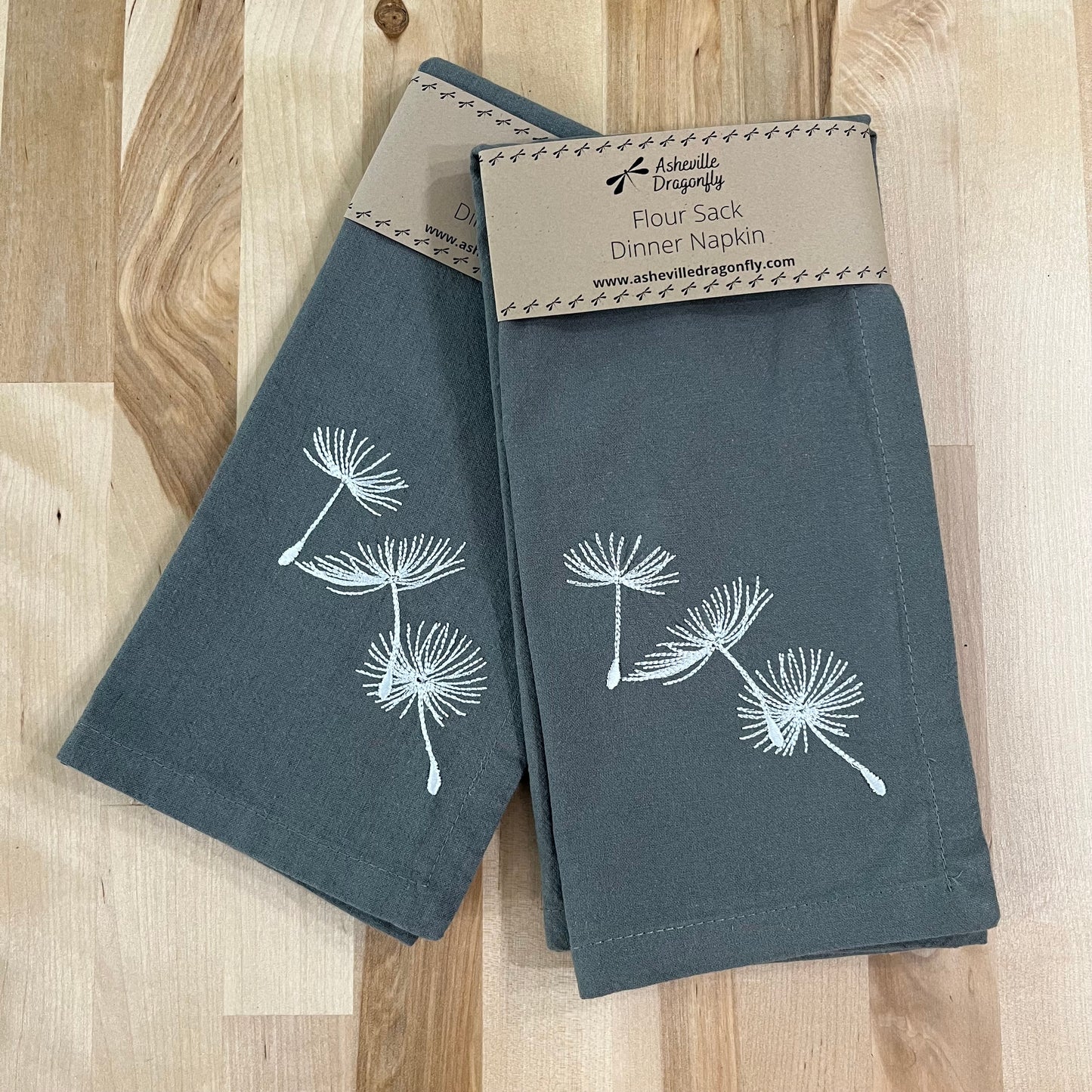 Blowing dandelion embroidered on grey napkin